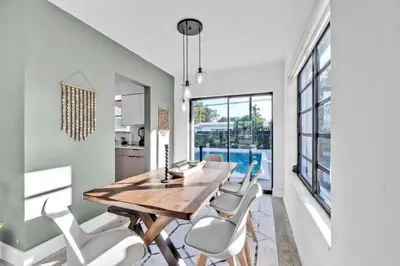 a dining room with a wooden table and chairs at Modern Pool Home Great for Families in Hollywood