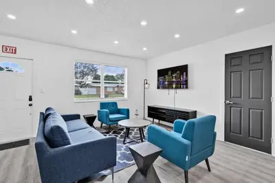 a living room with two blue chairs and a table at Modern Home 3 Bedrooms with Pool, 18 minutes to Ocean in Hollywood