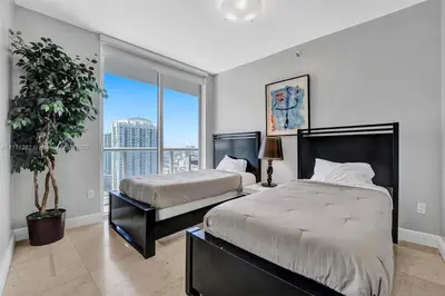 a bedroom with two beds and a large window at Waterfront Luxury Apartment 2 Bedrooms IconBrickell in Miami
