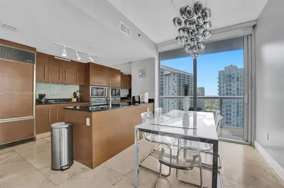 a kitchen with a dining table and a large window at Waterfront Luxury Apartment 2 Bedrooms IconBrickell in Miami