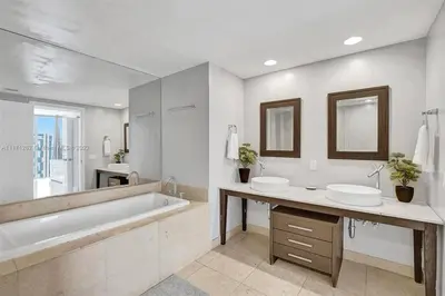 a white bathroom with two sinks and a tub and a tubermott at Waterfront Luxury Apartment 2 Bedrooms IconBrickell in Miami