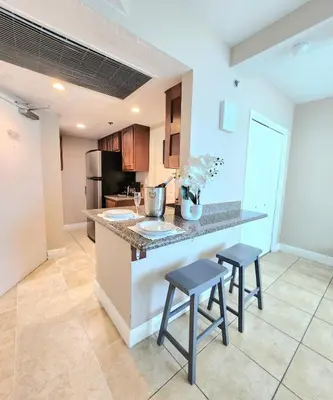 a kitchen with two stools at a kitchen counter at Beachfront Property Pool Gym Tennis Miami Beach! in Miami Beach
