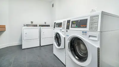 a laundry room with three washing machines and a washer and dryer at Tides Ocean Retreat by Cielo Stays in Hollywood