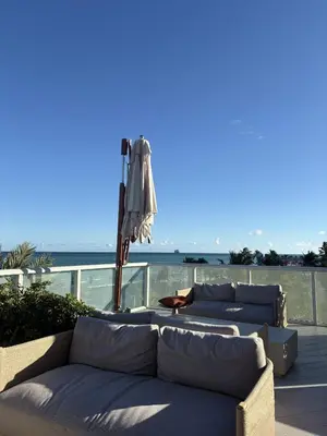 a group of couches sitting on a patio with an umbrella at Beachfront-Spacious W Residence in Fort Lauderdale