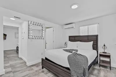 a white bedroom with a large bed and a mirror at Lovely 2 bedroom Studios-Suite Walking Distance To Ocean in Hollywood