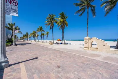 a beach with palm trees and the ocean at Lovely 2 bedroom Studios-Suite Walking Distance To Ocean in Hollywood