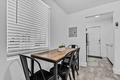 a dining room with a wooden table and black chairs at Lovely 2 bedroom Studios-Suite Walking Distance To Ocean in Hollywood