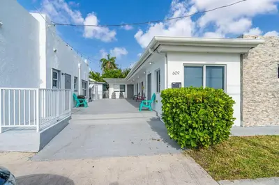 a white house with blue chairs in front of it at Lovely Studio Walking Distance To Ocean - Suite 7 in Hollywood