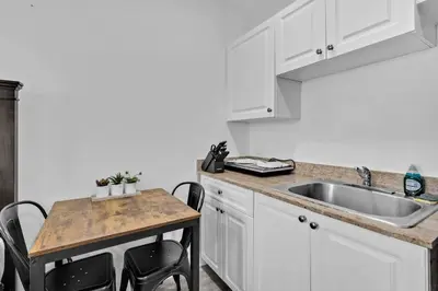 a kitchen with a sink and a table with chairs at Lovely Studio Walking Distance To Ocean - Suite 7 in Hollywood