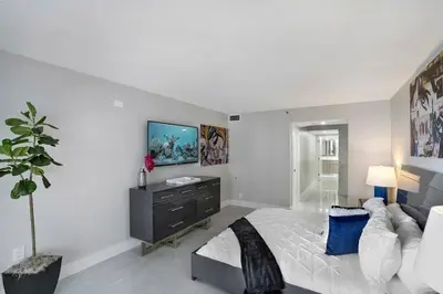 a bedroom with a bed and a tv on a wall at Calypso - Gorgeous Miami Renovated Spacious Condo! in Miami