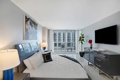 a large living room with a white couch and a tv at Calypso - Gorgeous Miami Renovated Spacious Condo! in Miami