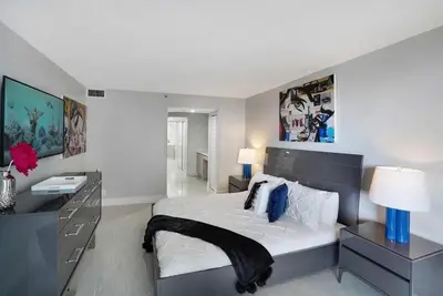 a bedroom with a large bed with a desk and a bed sidx sidx sidx sidx at Calypso - Gorgeous Miami Renovated Spacious Condo! in Miami