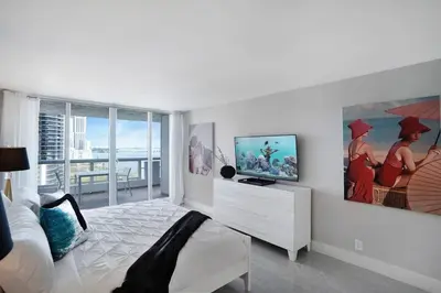 a white living room with a tv and a couch at Shock Wave! NEW Renovated Condo With Water Views! in Miami