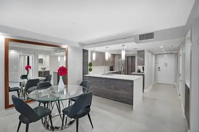 a dining room and kitchen with a glass table and chairs at Electric Love Brand New With Water View, Edgewater in Miami