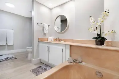 a bathroom with a tub and a sink and a mirror at Endless Summer! Incredible Water Views in Miami