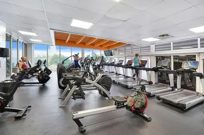 a gym with several treadmills and people in the gym at Endless Summer! Incredible Water Views in Miami