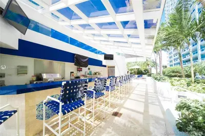 a bar with blue chairs at a resort at Sky High Penthouse! Water & City Views (top floor) in Miami