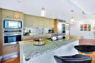 a kitchen with a marble counter top and a stove at Wait N' Sea! Direct Water Views, Steps From Pool! in Miami