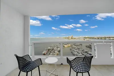 a balcony with a view of a harbor with boats at Permanent Vacation! Direct Water Views! in Miami