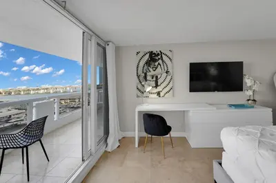 a white living room with a desk and a tv at Permanent Vacation! Direct Water Views! in Miami