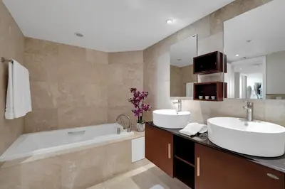 a bathroom with a tub and a sink and a tub and a mirror at Permanent Vacation! Direct Water Views! in Miami
