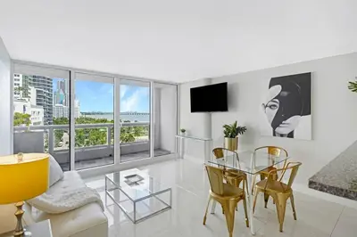 a living room with a glass table and chairs at Dance with me! Water and Park Views! in Miami