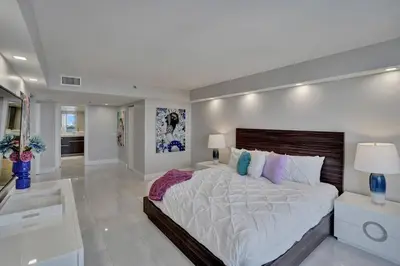 a large white bedroom with a large bed in it at A Wave From It All! Direct water views! in Miami