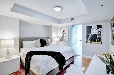 a white bedroom with a bed and a table at Sea Forever! Miami Skyline And Water Views in Miami