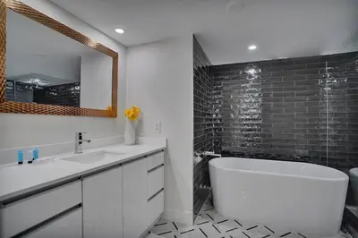 a bathroom with a tub and a sink and a mirror at GoldDust - Water and City Views! in Miami