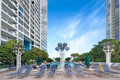 a group of chairs and a pool in front of a building at GoldDust - Water and City Views! in Miami