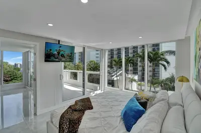 a living room with a white couch and a large window at GoldDust - Water and City Views! in Miami