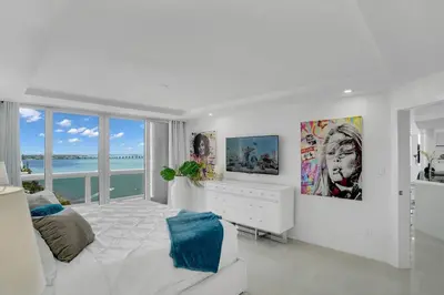a white bedroom with a white bed and views of the ocean at Walking on Water! Water Views! in Miami