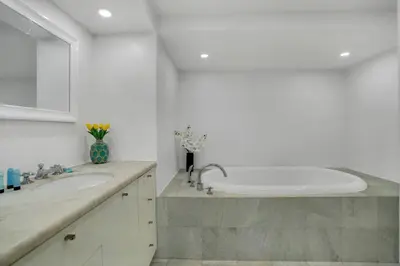 a white bathroom with a sink and a tub at Walking on Water! Water Views! in Miami