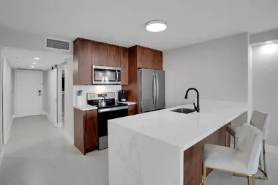 a kitchen with a white counter top and wooden cabinets at Fantasy! Water & Park Views! in Miami