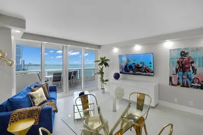 a living room with a blue couch and a table at Fantasy! Water & Park Views! in Miami