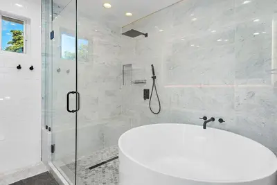 a white bathroom with a shower and a sink at Beautiful Villa with heated pool Must seen! in Miami