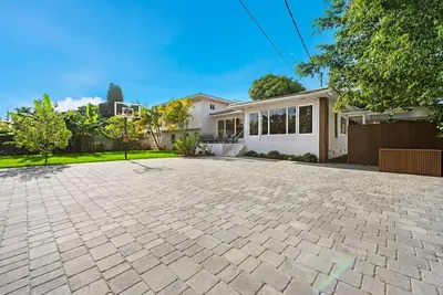 a home with a brick driveway in front of a house at Beautiful Villa with heated pool Must seen! in Miami