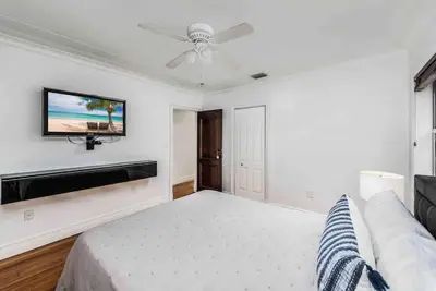 a bedroom with a bed and a tv on the wall at Villa sleeps 18 in Miami Shores with Movie theater / Pool / Jacuzzi in Miami
