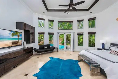 a bedroom with a large bed and a large blue rug at Villa sleeps 18 in Miami Shores with Movie theater / Pool / Jacuzzi in Miami