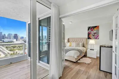 a bedroom with a bed and a large window at Aqua Marina! Water & City Views! in Miami