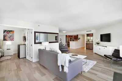 a white living room with a couch and a table at Aqua Marina! Water & City Views! in Miami