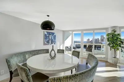 a dining room with a white table and chairs at Over The Moon! Miami Skyline and Water Views! in Miami