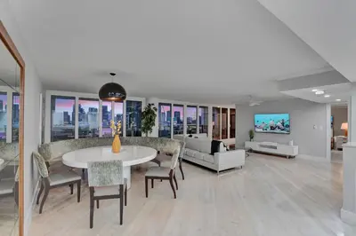 a living room with a table and chairs and a couch at Over The Moon! Miami Skyline and Water Views! in Miami