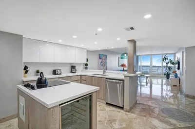 a large kitchen with white cabinets and a counter top at First Class! - Crystal clear water views! in Miami