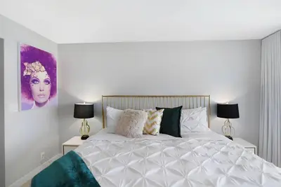 a bedroom with a large white bed with two lamps at Good Morning Beautiful! Direct Water Views in Miami