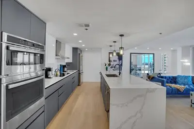 a kitchen with stainless steel appliances and a living room at Make It Happen! Brand New with Amazing Water Views in Miami