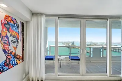 a room with sliding glass doors with a view of the ocean at Sunset Hideaway! Direct Water Views and Renovated! in Miami