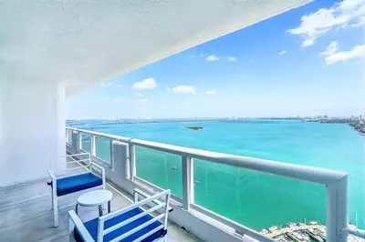 a balcony with blue chairs and a view of the ocean at Sunset Hideaway! Direct Water Views and Renovated! in Miami