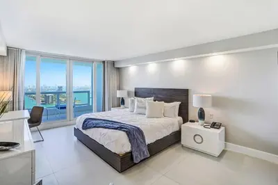 a bedroom with a large bed and a large window at Sunset Hideaway! Direct Water Views and Renovated! in Miami