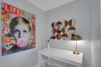 a white room with a painting of a woman with a pink balloon at Cloud Nine! Direct Water Views of Bay & Ocean! in Miami